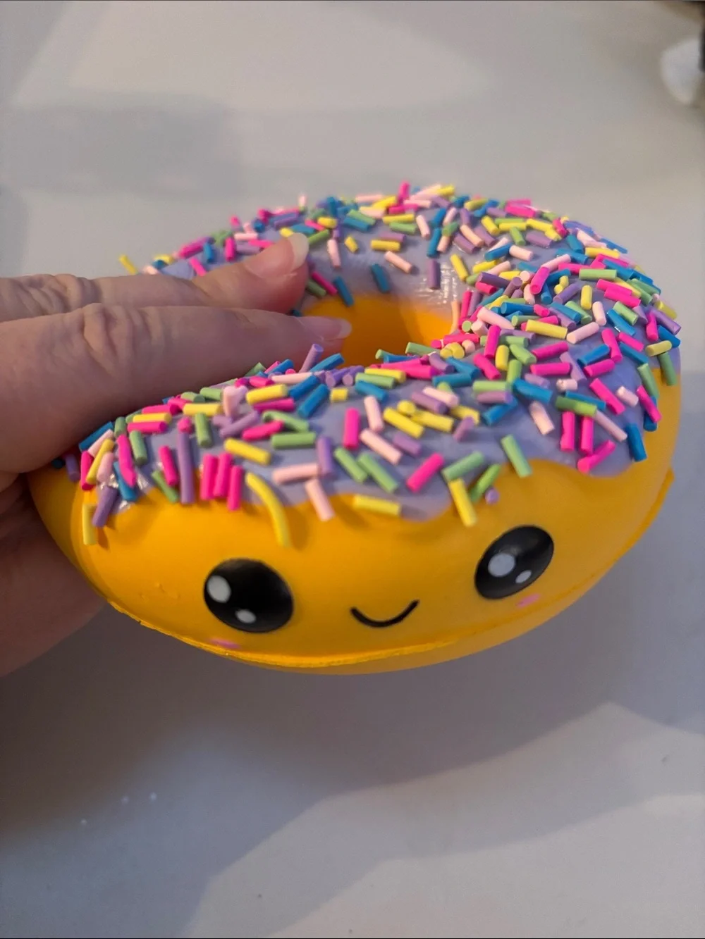Smiling Yellow Donut Plush Toy with Purple Frosting and Rainbow Sprinkles